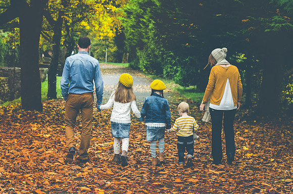 family-walking-on-the -fallen-leaves